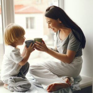 mother-little-son-sitting-windowsill-with-tea_1157-29388